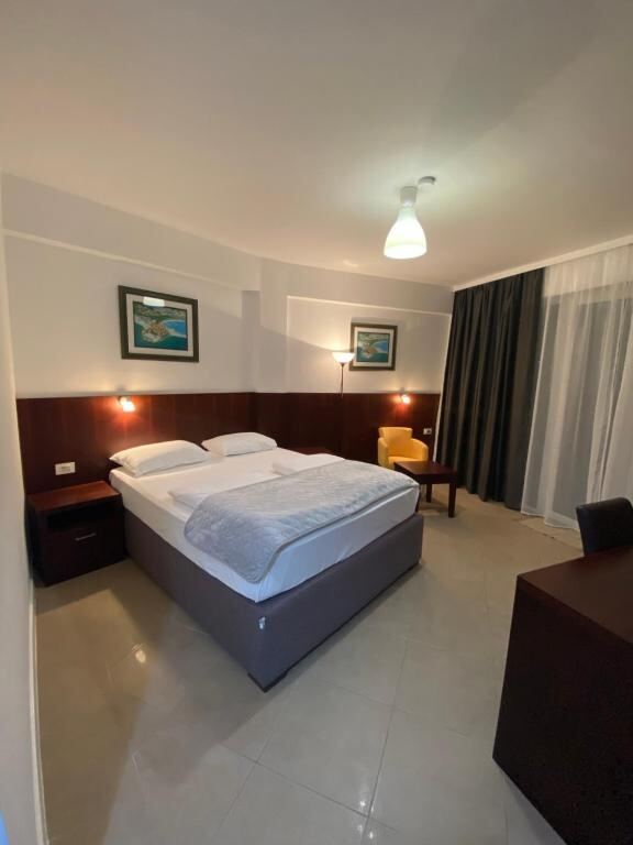 Spacious room with a double bed at Hotel Vienna in Igalo